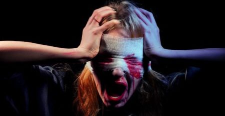 scared bloody girl screaming on black background with copyspace